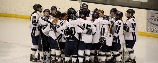 Womens ice hockey team huddles in celebration of their ECAC Championship.