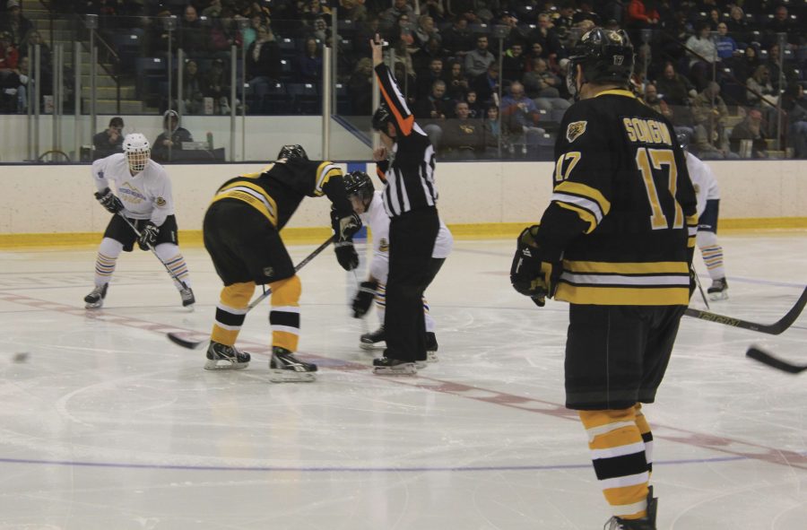 Bruins+alumni+and+Crotched+Mountain+Wild+face-off+at+center+ice.