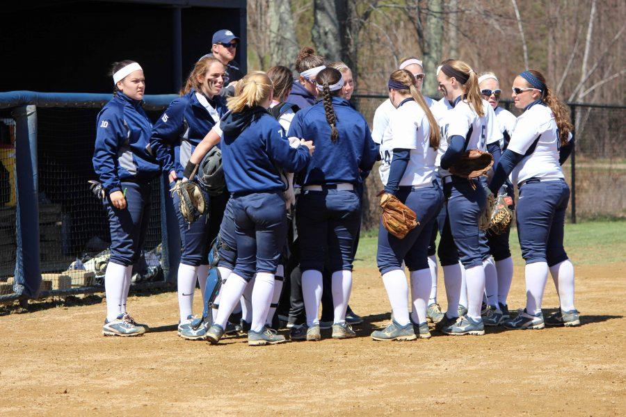 Hawks softball huddling together on the field.