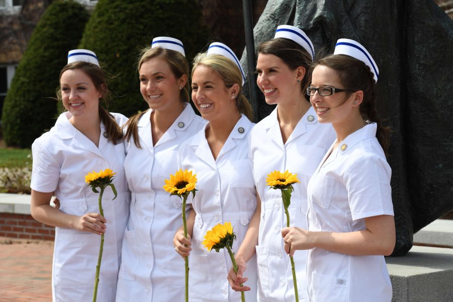 Class of 2016 nursing majors Abby Wintersteen, Meagan Halligan, Ashley Bradley, Alex Bamford, and Jessica Gipson pose in front of Alumni Hall after pinning ceremony.