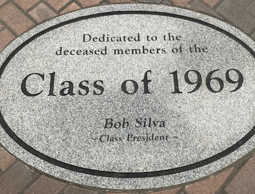 Seal in front of commemorative benches dedicated to passed alumni of 1969