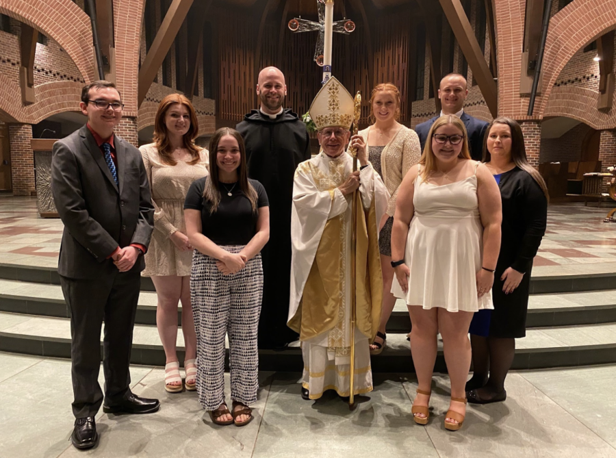 Br. George Rumley, O.S.B., Bishop Peter Anthony Libasci, and seven RCIA
candidates smile at the RCIA Mass in 2022.