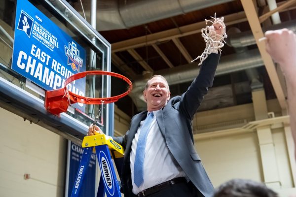 Coach Keith Dickson cuts the net as Saint Anselm advanced to the final 4 in 2018