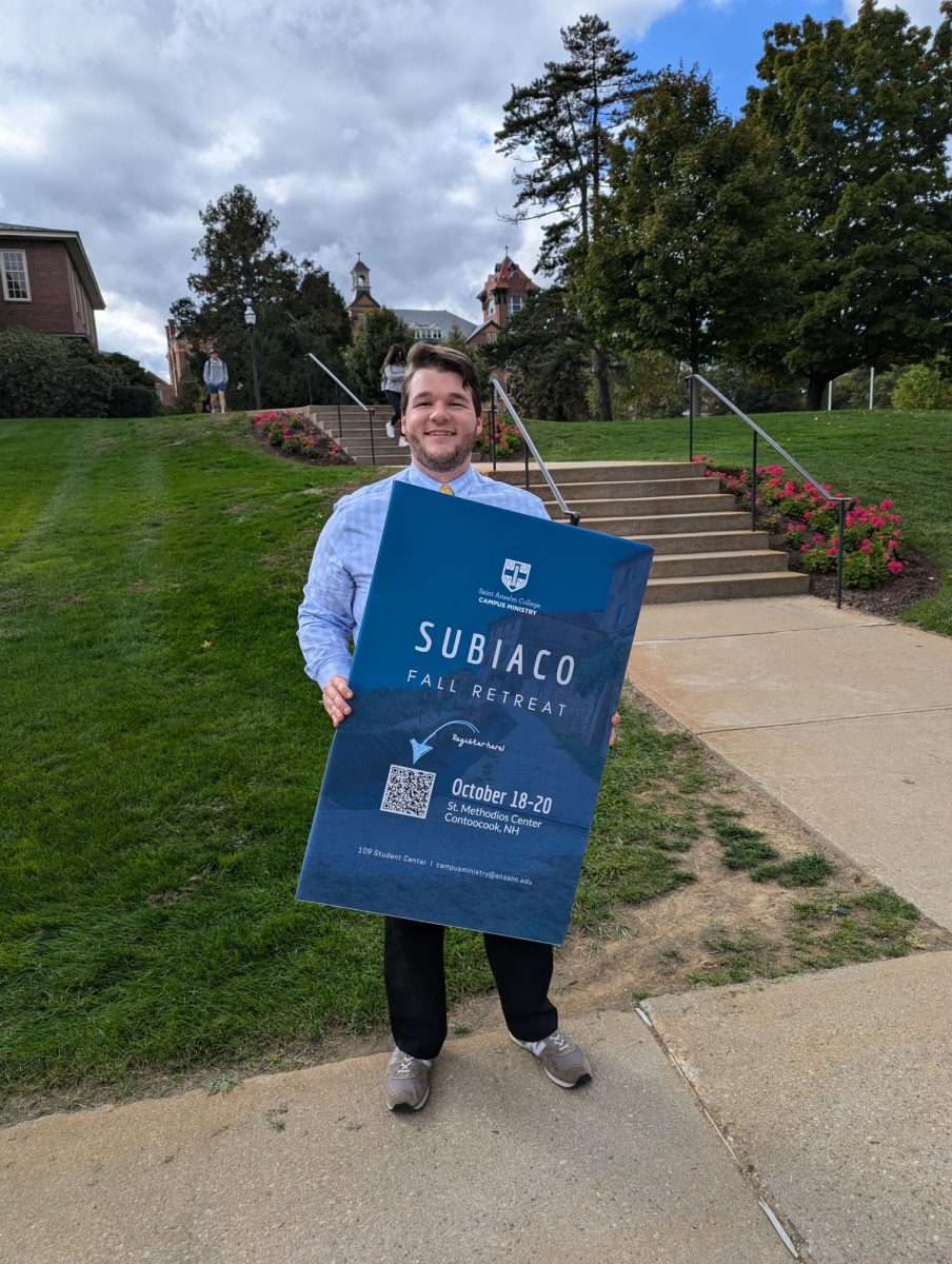  Daniel O’Malley, Faith Formation at Campus Ministry, prepares the Subiaco Retreat sign.