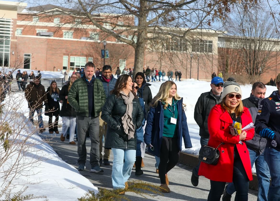 Prospective students tour campus with smiles despite cold weather.